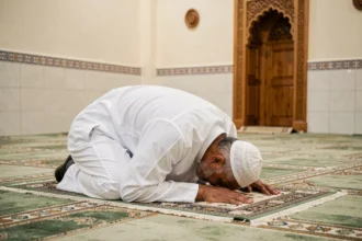 Homme en prière sur un tapis de prière dans une mosquée de banlieue parisienne à Sarcelles